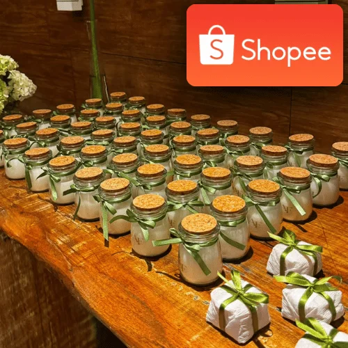 Dezenas de velas de lembrancinha em potes com rolha e laço verde, com o selo da Shopee